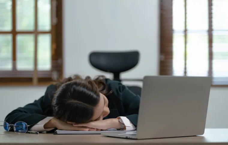 A woman sleeping at work due to insufficient sleep.